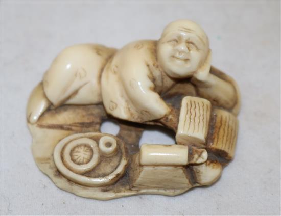 A Japanese ivory netsuke of a reclining man and an ivory mask, possibly Hotei, 19th/early 20th century, 3.9cm and 3.6cm